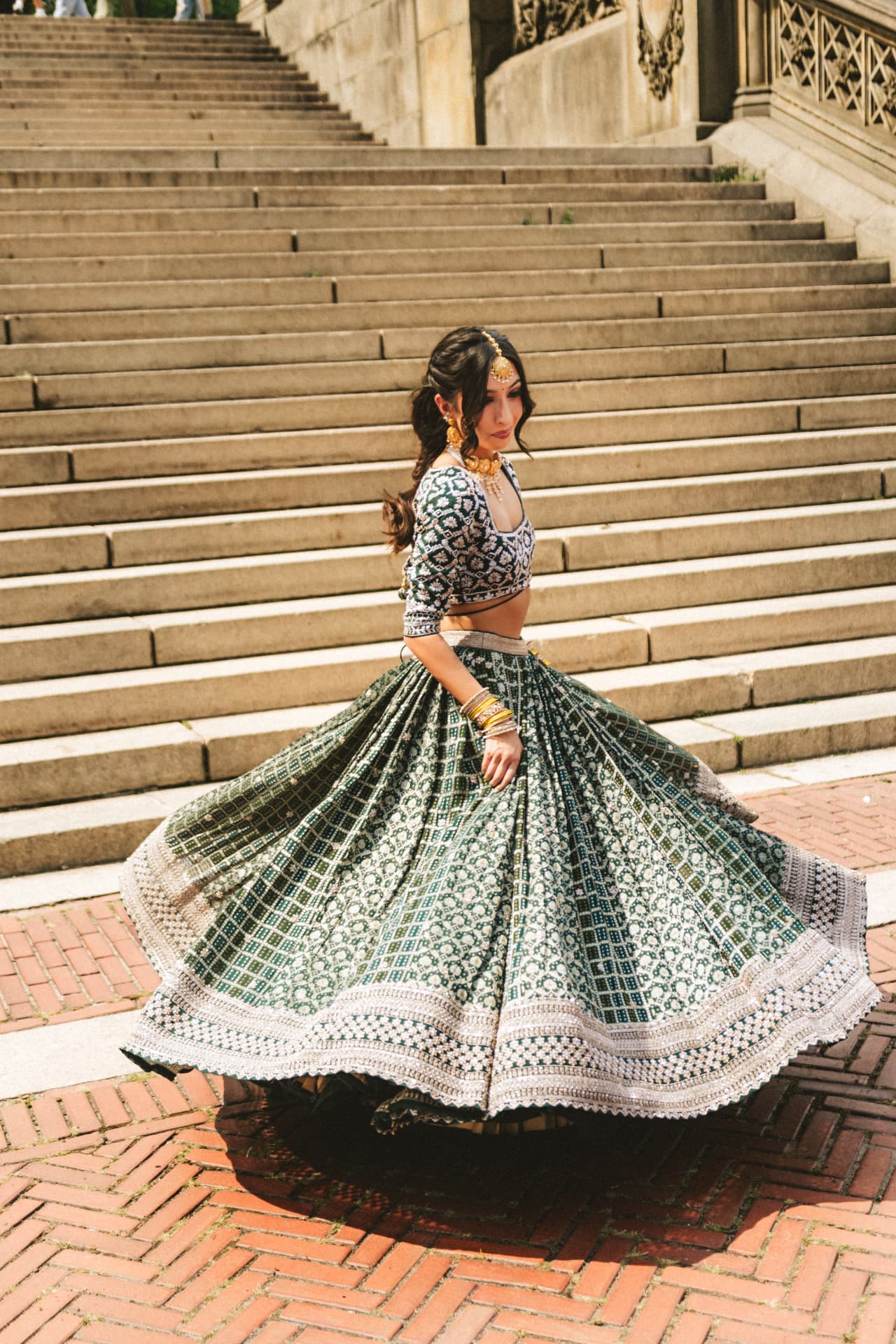 Model twirling in an emerald bandhani lehenga on the Bethesda steps